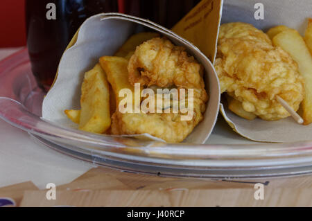 Gamberetti, le patate e le verdure in pastella, fritti . Cucina di strada in imballaggio di cartone. Foto Stock