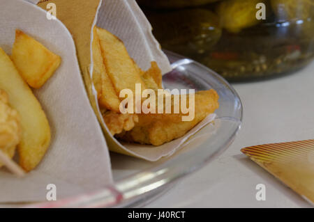 Gamberetti, le patate e le verdure in pastella, fritti . Cucina di strada in imballaggio di cartone. Foto Stock