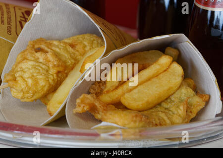 Gamberetti, le patate e le verdure in pastella, fritti . Cucina di strada in imballaggio di cartone. Foto Stock