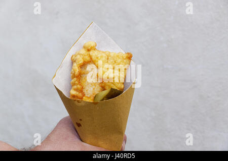 Gamberetti, le patate e le verdure in pastella, fritti . Cucina di strada in imballaggio di cartone. Foto Stock