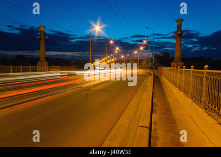 I traccianti da macchine passando sul ponte al tramonto. Dnepropetrovsk, Ucraina Foto Stock