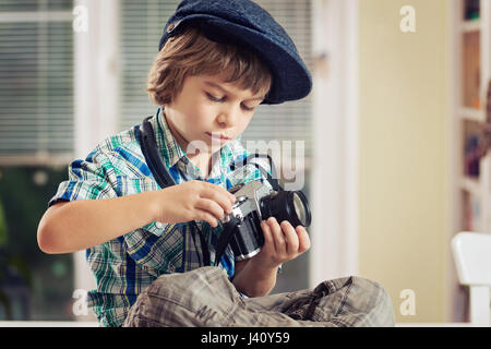 Little Boy holding vintage cinepresa. Foto Stock