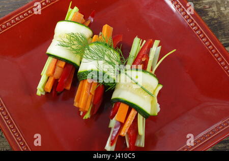 Avvolte le zucchine con i pomodori paprika sulla piastra Foto Stock