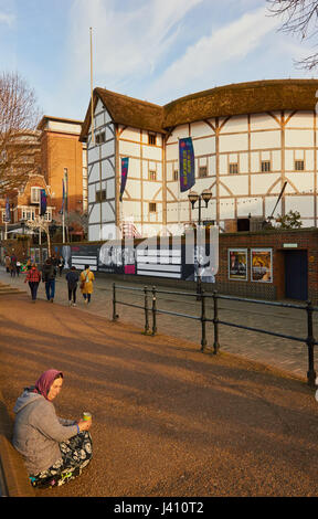 Donna seduta su un marciapiede di accattonaggio nei pressi del Teatro Globe, South Bank, Southwark, Londra, Inghilterra Foto Stock