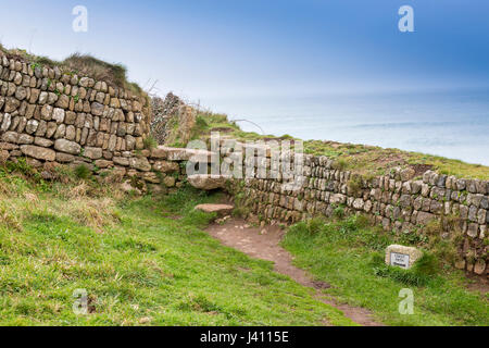 Una fase di stile in una pietra a secco muro costruito da blocchi di granito di diverse dimensioni e colori a Cape Cornwall, Cornwall, Regno Unito Foto Stock