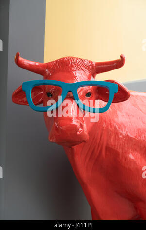 Full Size modello Red cow indossando occhiali blu al di fuori del negozio ottici a Funchal, Madeira Foto Stock