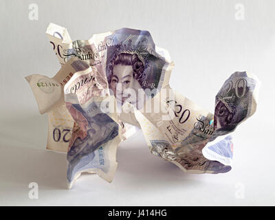 Focus-impilati composizione di tre accartocciata venti-pound note, luce naturale, su carta bianca di formato sfondo con sottili ombre. Testa della regina distorta. Foto Stock