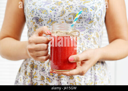 Primo piano della detox smoothie con fragola in vaso con manico in mani femminili Foto Stock