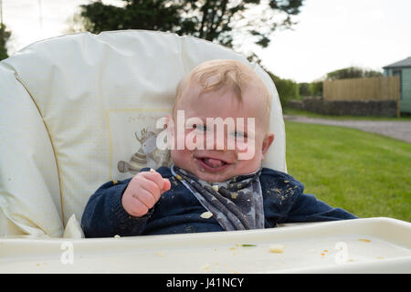 Bambino di sette Mesi in seggiolone, Hope Cove, Devon, Inghilterra, Regno Unito. Foto Stock