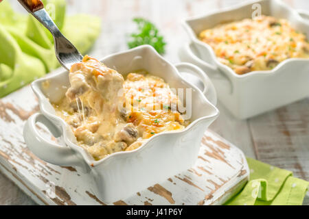 Gratinati al forno pollo in casseruola con funghi in salsa alla panna con formaggio Foto Stock