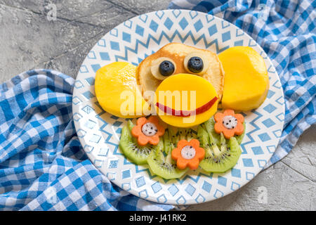 Funny monkey pancake con frutta per bambini prima colazione Foto Stock