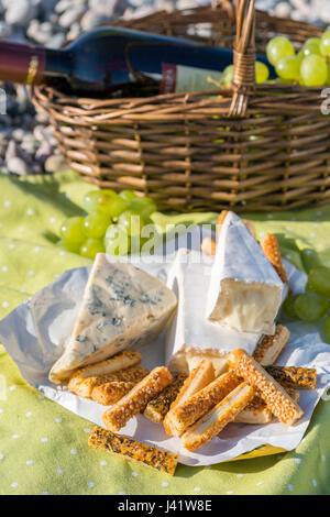 Cesto picnic con vino, formaggio e Uva su un'erba Foto Stock