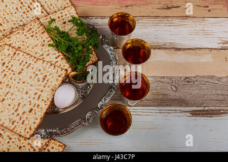 Matzo, l'uovo e il vino per la festa di pasqua Matzo per Pasqua con barra in metallo e il vino sulla tavola da vicino Foto Stock