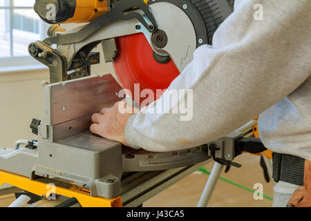 L'uomo, lavoratore segatura di legno con una sega circolare, la macchina per il taglio di legno. Fabbricazione di mobili. Accessori per mobili. Macchina per il taglio di pannelli MDF, p Foto Stock