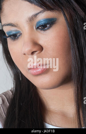 Giovane e bella donna di colore blu da indossare ombretto trucco Foto Stock