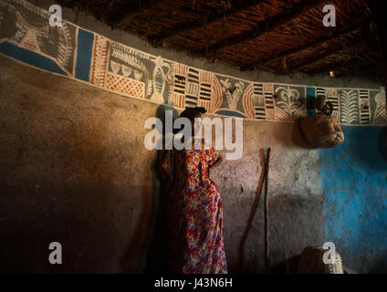 Donna etiope dentro il suo tradizionale e dipinto e decorate casa, Kembata, Alaba Kuito, Etiopia Foto Stock