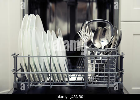 Pulire posate e piatti dopo il lavaggio in lavastoviglie Foto Stock