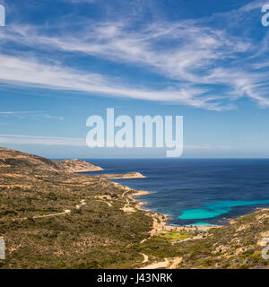 Vista della macchia mediterranea e la fascia costiera della Revellata vicino a Calvi lungo la costa occidentale della Corsica guardando verso il faro in distanza e mediterraneo turchese s Foto Stock