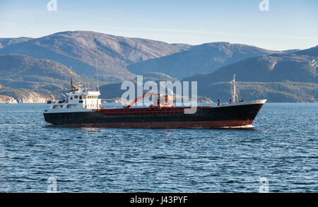 Nave industriale con escavatore sul ponte passa sul mare di Norvegia, regione di Trondheim Foto Stock