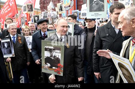 Mosca, Russia. 9 maggio 2017. Il presidente russo Vladimir Putin, detiene un ritratto del suo veterano di guerra padre Spiridonovich Vladimir Putin, durante il reggimento immortale patriottica marcatura di marzo la vittoria annuale celebrazione della giornata e la 72anniversario della fine della II Guerra Mondiale in Piazza Rossa Maggio 9, 2017 a Mosca, in Russia. Credito: Planetpix/Alamy Live News Foto Stock
