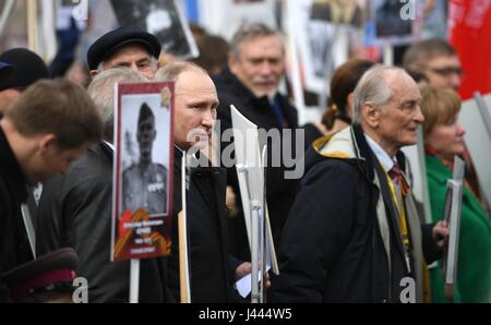 Mosca, Russia. 9 maggio 2017. Il presidente russo Vladimir Putin, detiene un ritratto del suo veterano di guerra padre Spiridonovich Vladimir Putin, durante il reggimento immortale patriottica marcatura di marzo la vittoria annuale celebrazione della giornata e la 72anniversario della fine della II Guerra Mondiale in Piazza Rossa Maggio 9, 2017 a Mosca, in Russia. Credito: Planetpix/Alamy Live News Foto Stock