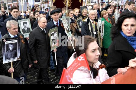 Mosca, Russia. 9 maggio 2017. Il presidente russo Vladimir Putin, centro detiene un ritratto del suo veterano di guerra padre Spiridonovich Vladimir Putin, come egli marche al fianco dell'ex artista sovietico Vasily Lanovoya durante il reggimento immortale patriottica marcatura di marzo la vittoria annuale celebrazione della giornata e la 72anniversario della fine della II Guerra Mondiale in Piazza Rossa Maggio 9, 2017 a Mosca, in Russia. Credito: Planetpix/Alamy Live News Foto Stock