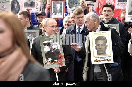 Mosca, Russia. 9 maggio 2017. Il presidente russo Vladimir Putin, centro detiene un ritratto del suo veterano di guerra padre Spiridonovich Vladimir Putin, come egli le chat con ex artista sovietico Vasily Lanovoya durante il reggimento immortale patriottica marcatura di marzo la vittoria annuale celebrazione della giornata e la 72anniversario della fine della II Guerra Mondiale in Piazza Rossa Maggio 9, 2017 a Mosca, in Russia. Credito: Planetpix/Alamy Live News Foto Stock