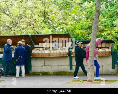 Il marciapiede davanti a un bouquiniste, di seconda mano libraio stallo in un giorno di pioggia. Quai de la Tournelle, Parigi, Francia. Foto Stock