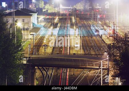 Le luci di coda rosse del treno express nella stazione ferroviaria di notte. Chocen, Repubblica Ceca Foto Stock