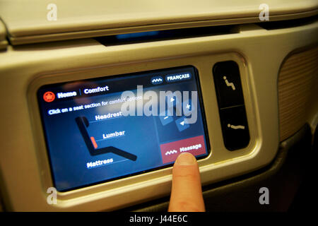 TORONTO, Canada - gennaio 28th, 2017: Air Canada Business class seat con il sistema di intrattenimento personale enorme monitor HD all'interno di un Boeing 777-300ER da AC. Aria di Canadas 777-300ER in classe business su questa configurazione è costituito da un totale di 40 posti come una inversione di lisca di pesce posti a sedere sparsi su due cabine, close-up del sedile personal display di controllo Foto Stock