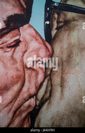 'Il Bacio' raffigurante leader sovietico Leonid Brezhnev e a est il Presidente tedesco Erich Honecker in un abbraccio fraterno dipinto sul muro di Berlino. Foto Stock