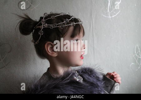 Bella dai capelli scuri ragazza con corona sulla parte superiore della testa sognando il principe Foto Stock