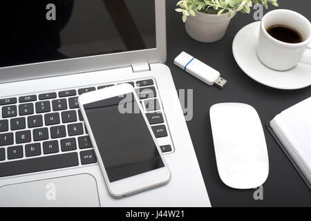 Smartphone e laptop mockup nero sulla scrivania in ufficio Foto Stock