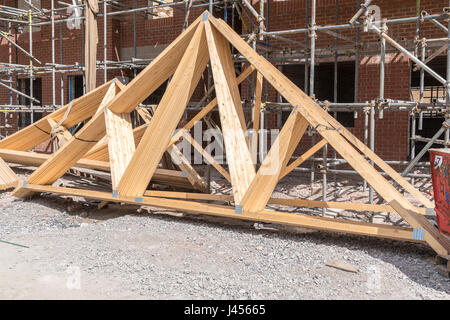 Case in costruzione con tetto a capriate pronto per l'installazione Foto Stock