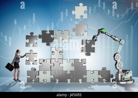 Imprenditrice facendo puzzle con il braccio robotico Foto Stock