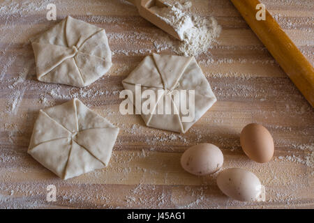 La pasticceria con formaggio e uova domestiche, laminazione di legno pin su una tavola di legno Foto Stock