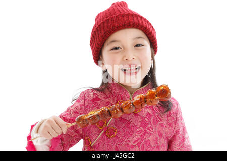 Felice bambina di mangiare i pomodori su bastoni Foto Stock