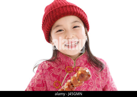 Felice bambina di mangiare i pomodori su bastoni Foto Stock