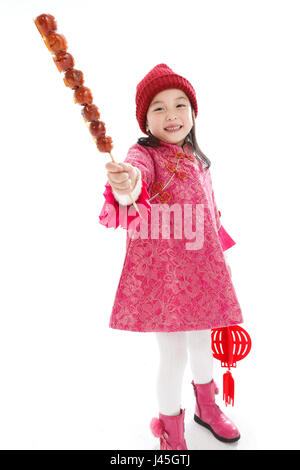 Felice bambina di mangiare i pomodori su bastoni Foto Stock