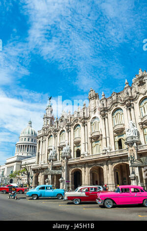 Vivacemente colorato vintage American cars stand parcheggiato davanti al punto di riferimento architettura del grande teatro di Havana, Cuba Foto Stock