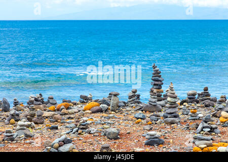 Rocce equilibrato su una spiaggia con l'oceano sullo sfondo a Tenerife, Spagna Foto Stock