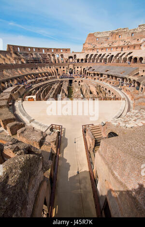 Un ampio angolo di vista interna dell'anfiteatro all'interno del Colosseo in una giornata di sole con cielo blu preso dal livello medio. Foto Stock