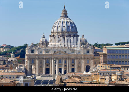 Compressi in prospettiva della Basilica di San Pietro a Roma dalla sommità del Castel Sant'Angelo in una giornata di sole con cielo blu. Foto Stock