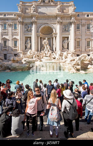 La fontana di Trevi Fontana di Trevi' a Roma con la folla di turisti e visitatori di scattare fotografie, posa e selfies in una giornata di sole con cielo blu. Foto Stock