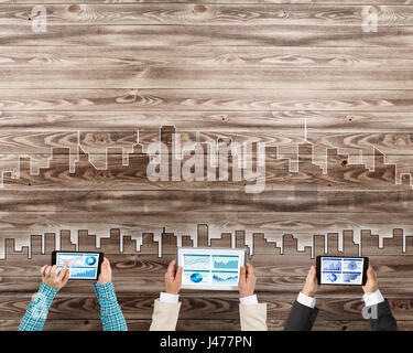 Un gruppo di tre persone con i dispositivi in mani lavorando insieme come simbolo del collegamento in rete e comunicazione Foto Stock