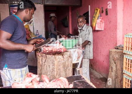 Un macellaio musulmano serve un cliente in un negozio di Negombo, Sri Lanka. Foto Stock