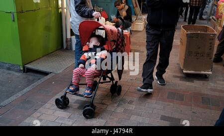 Il bambino nel passeggino Sham Sui Po a Apliu Street Il Mercato delle Pulci di Hong Kong Foto Stock