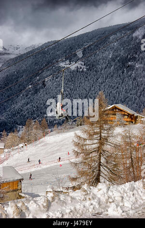 Gli sciatori che viaggiano su un impianto di risalita con gli sciatori utilizzando le piste al di sotto, Sainte Foy, Nord Alpi Francesi, Francia Foto Stock