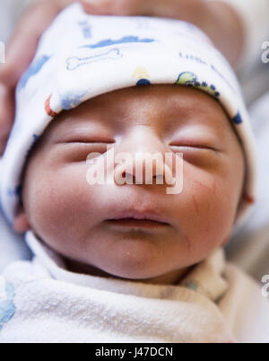 Close-up verticale di un neonato razza mista biracial Asian Caucasian baby boy sleeping minuti dopo essere nato nel mondo Foto Stock