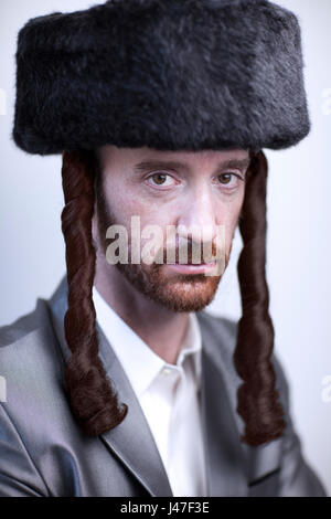 Bello ebrea ortodossa Hasidim uomo rabbi con barba rossa in un grande cappello di pelliccia e serrature laterali in una pelle di pescecane in argento suit Foto Stock